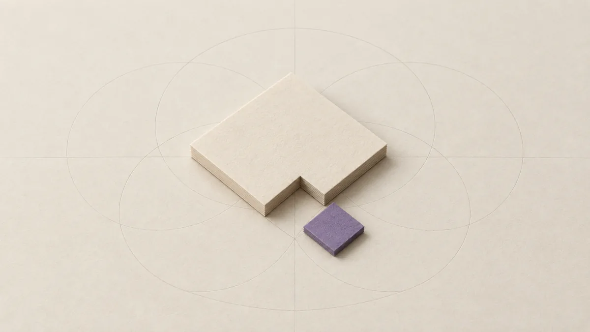 A thick cream paper square with one corner cut away, and the small violet square that fills it lying beside the gap.