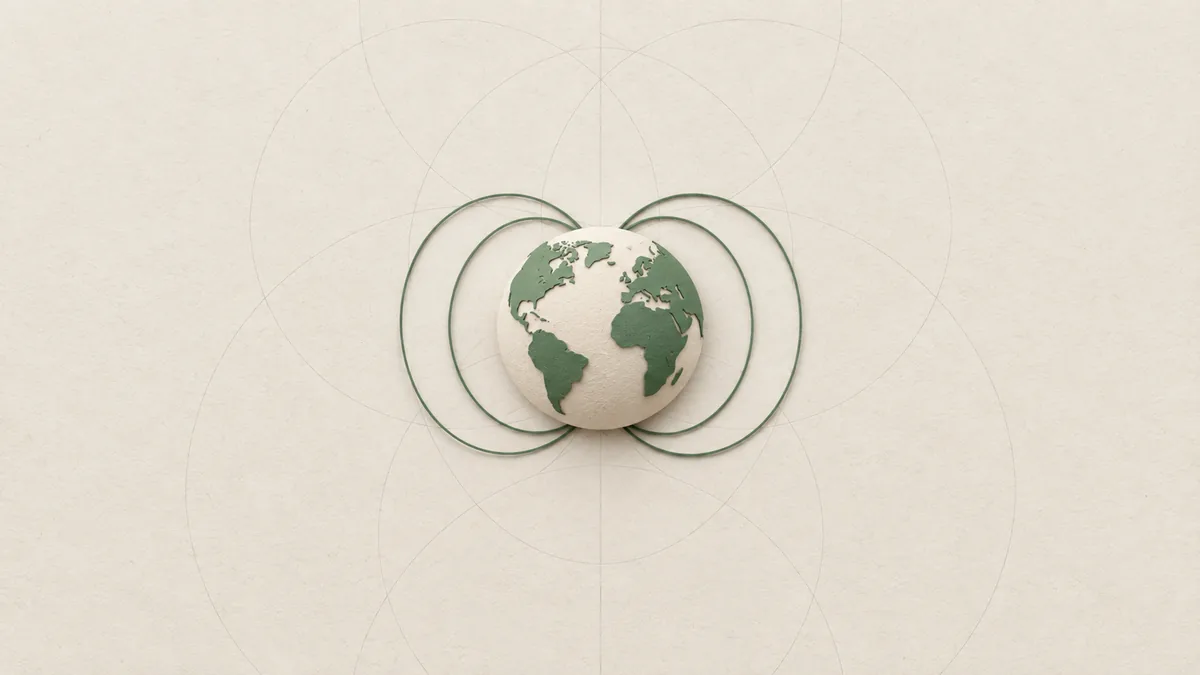 A cut-paper globe with a few thin green arcs bowing out from pole to pole, on warm off-white paper.