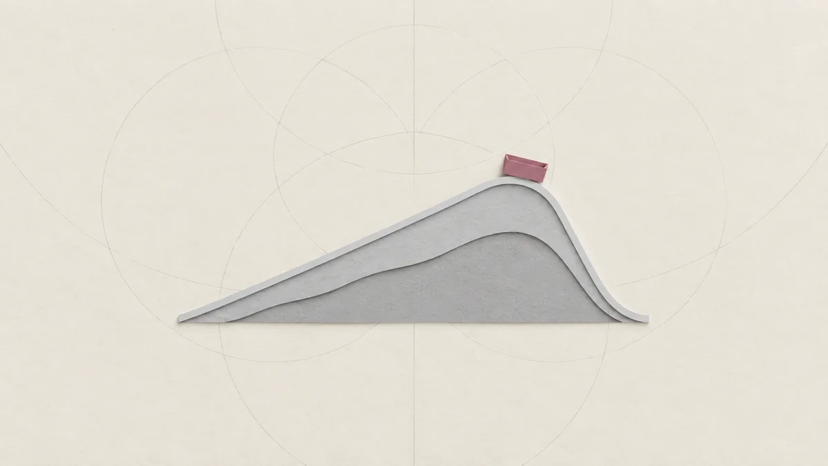 A steep cut-paper hill of rollercoaster track with one small empty pink car at its crest, on warm off-white paper.