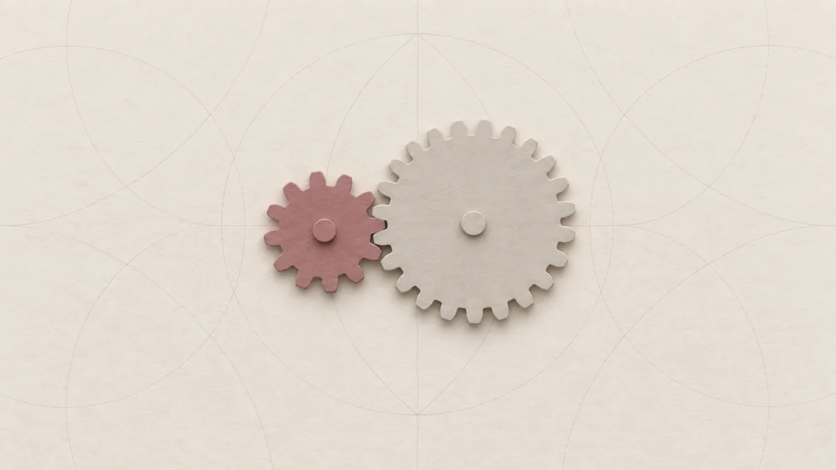 Two meshed paper gears, a small pink one and a large pale one, centred on warm off-white paper.