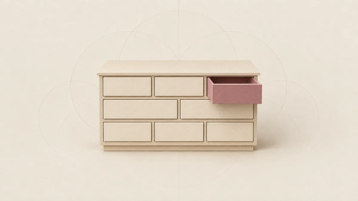 A small cut-paper chest of eight plain drawers, the top right one pulled out and pink, on warm off-white paper.