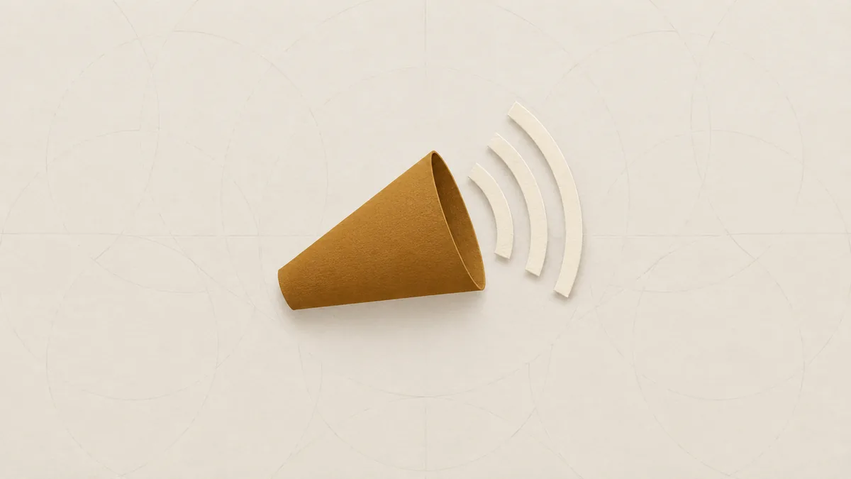 A cone-shaped megaphone of amber paper with three pale paper arcs widening from its open end, on off-white paper.